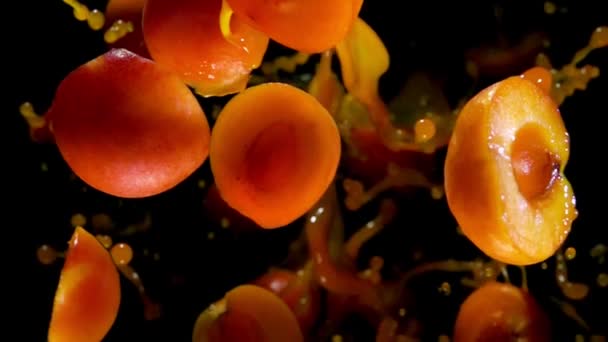 Половинки абрикоса отскакивают от брызг сока — стоковое видео