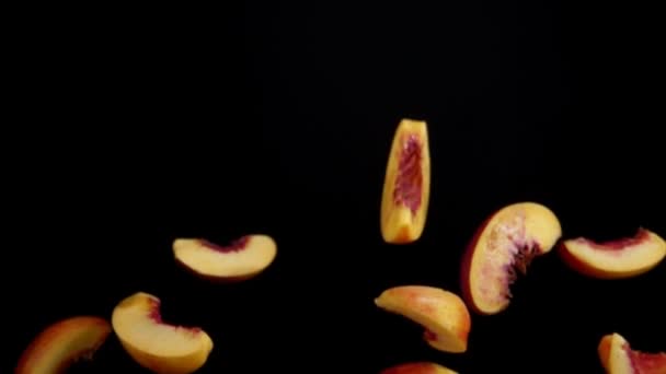 Peach slices bounce on a black background — Stock Video