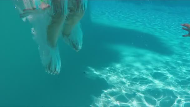 Meisje in helder zwembroekje duikt onder water — Stockvideo