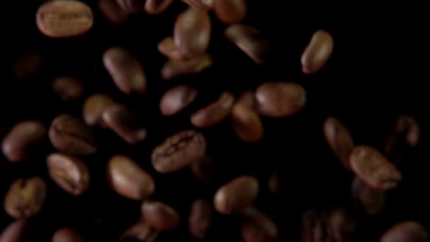 Grains de café volent et tournent sur un fond noir — Video