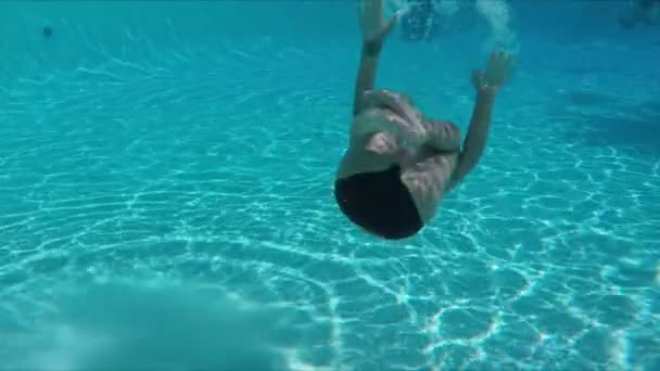 Happy boy rotating double somersault in the pool — Stock video