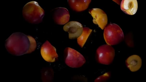 Pfirsichhälften fliegen und hüpfen in Wassertropfen — Stockvideo