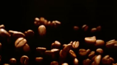 Roasted coffee beans fly and spin in slow motion