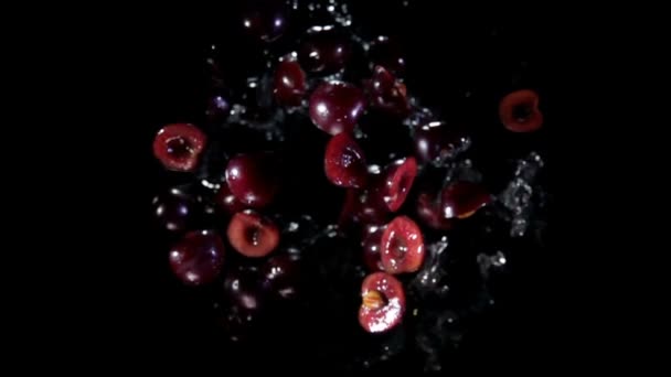 Половина вишни скачет вверх с брызгами воды — стоковое видео