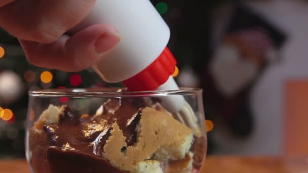 Creme espremido na sobremesa contra a árvore de Natal — Vídeo de Stock