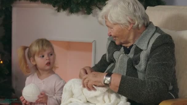 Grootmoeder laat haar kleindochter zien hoe ze moet breien — Stockvideo