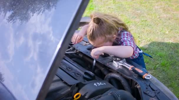 Kleines Mädchen spielt Mechanik und repariert Auto-Motor — Stockvideo