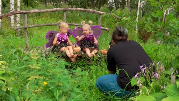 Фотограф фотографирует девушек-бабочек — стоковое видео
