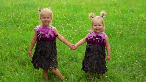 Zwei Mädchen in einem Kleid aus Blättern und Blumen — Stockvideo