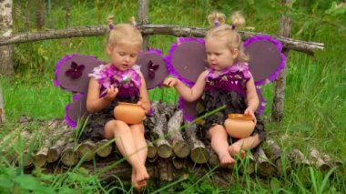 Kelebek kanatlı kızlar saksıdan bal yiyor.