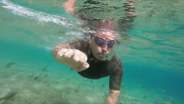 Mergulhador nada ao longo do recife de coral com peixes tropicais — Vídeo de Stock
