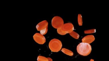 Siyah arka planda uçan taze havuçlar.