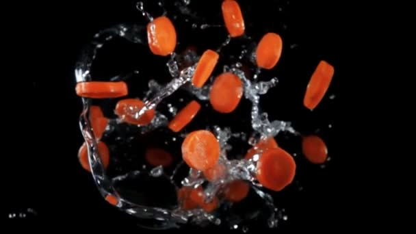 Свіжа морква, що літає з бризками води — стокове відео