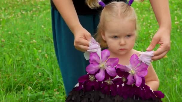 Жінка одягнула дівчину в фантастичну сукню з квітів — стокове відео