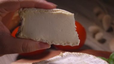 Parmaklar yumuşak keçi peynirinden bir parça sıkar
