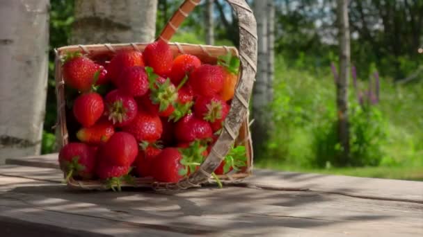 딸기가 담긴 바구니가 탁자 위로 떨어지고 있습니다 — 비디오