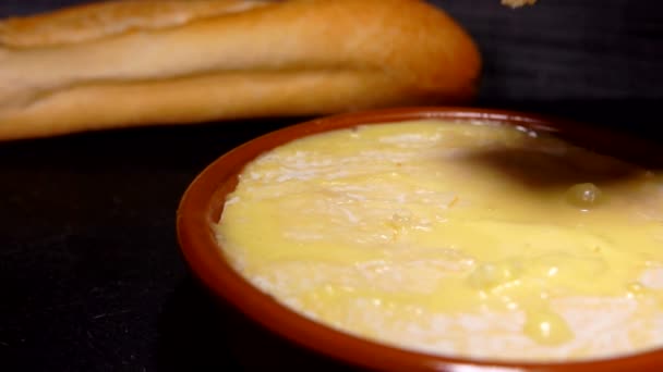 Baguette quebra uma crosta em um queijo suave pré-aquecido — Vídeo de Stock