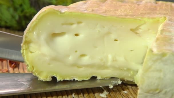 Piece of a creamy brie taken out from whole cheese — Stockvideo