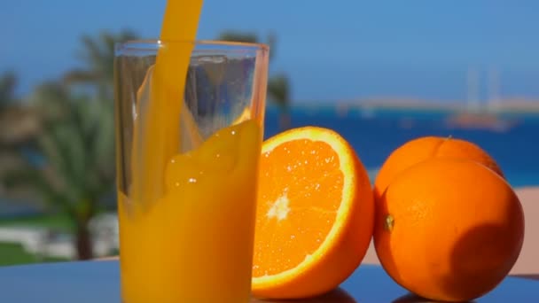 Вкусный апельсиновый сок налили в стакан — стоковое видео