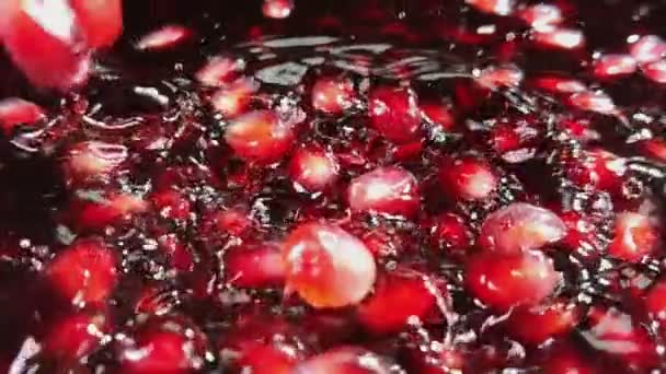 Los granos rojos están cayendo en el jugo de granada — Vídeo de stock