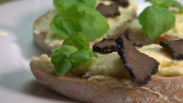 Bruschetta met zwarte truffel plakjes op de kaas — Stockvideo