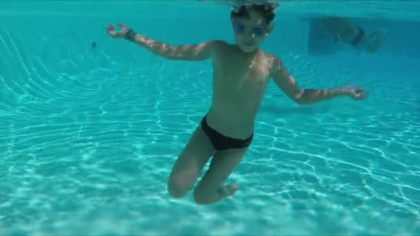 Niño haciendo un somersalts bajo el agua en la piscina — Vídeos de Stock