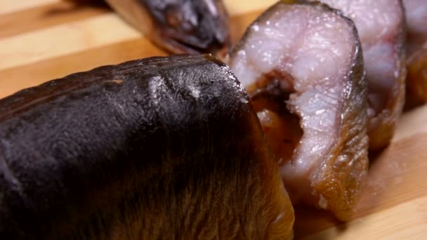 Köstliche geräucherte Aalstücke auf einem Holzbrett — Stockvideo