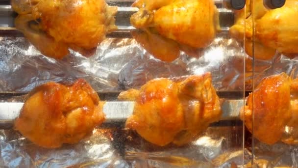A csirkék egy nagy grillsütőn forognak. — Stock videók