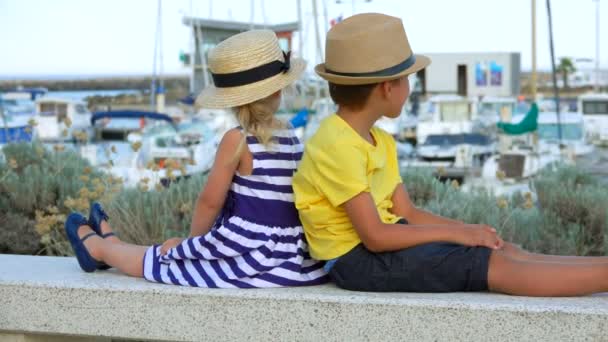 Los niños están sentados en el fondo de un puerto de yates — Vídeos de Stock