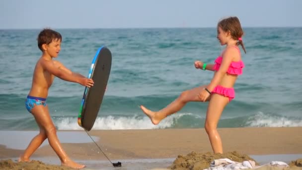 Kinderen spetteren elkaar met zeewater — Stockvideo