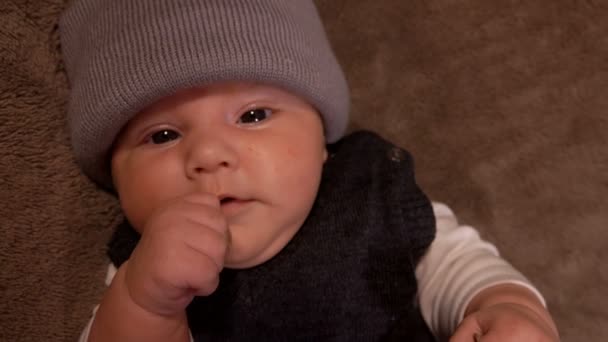 Pequeño adorable bebé de ojos negros con un sombrero gris — Vídeo de stock