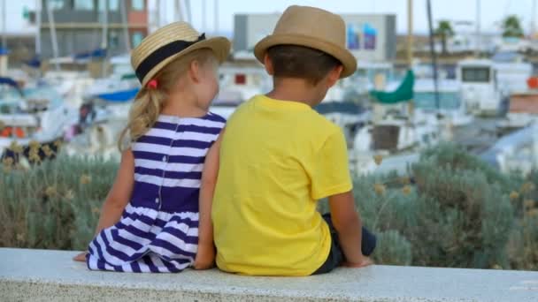 Jongen en meisje met hoeden zwaaien synchroon — Stockvideo