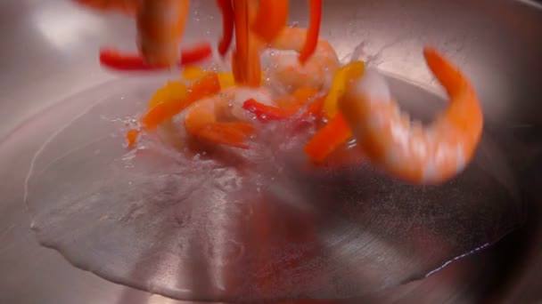 Shrimps and pepper fall in a hot oil on the pan — ストック動画