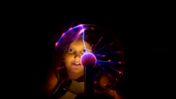 Girl touches the Tesla lamp with her hands — Stock Video