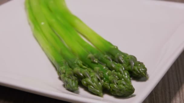 Сырный соус выливается на зеленые спаржевые копья — стоковое видео