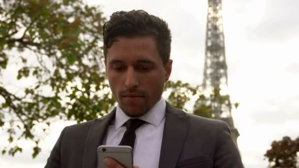 Чоловік у костюмі, який друкує повідомлення на мобільному телефоні — стокове відео