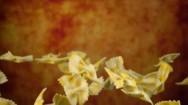 Pasta Farfalle flyger upp på gul ochre bakgrund — Stockvideo