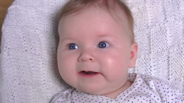 Primer plano del bebé acostado sobre una manta blanca — Vídeos de Stock