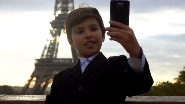 Мальчик делает селфи на фоне Эйфелевой башни — стоковое видео