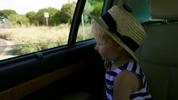Menina loira está montando no carro no banco de trás — Vídeo de Stock