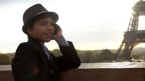 Chico en un sombrero está hablando y riendo por teléfono — Vídeos de Stock