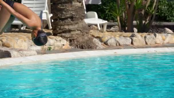 Мальчик-сальто прыгает в бассейн — стоковое видео