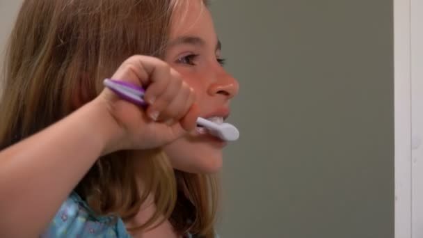Girl cleans her teeth carefully — ストック動画