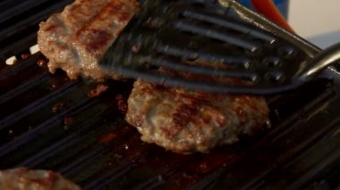 Biftek ızgaraya spatulayla bastırılır.