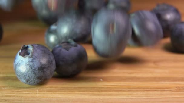 Large blueberries fall on a wooden table — 图库视频影像