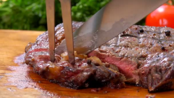 Knife cuts a prepared meat steak onto slices — Stock Video