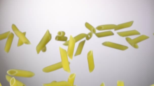 Torr pasta penne flyga upp på en vit bakgrund — Stockvideo