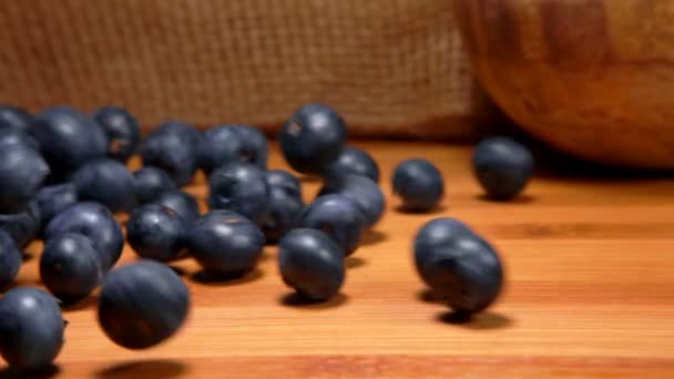 成熟的蓝莓在桌子的木制表面上滚着 — 图库视频影像