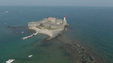 Küçük bir adada deniz feneri olan eski bir deniz kalesinin hava manzarası.