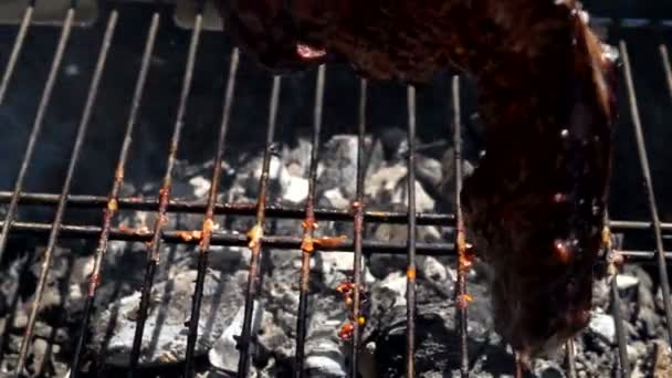 Délicieux steak de viande retourné sur le gril avec des pinces à viande — Video